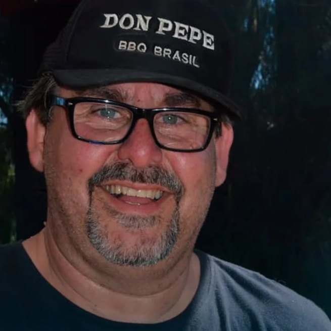 Retrato de Don Pepe sorrindo, de óculos e boné Don Pepe BBQ Brasil
